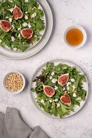 Photo for Food photography of salad with goat cheese; fig; feta; leaf; lettuce, rocket, pine nuts; honey - Royalty Free Image