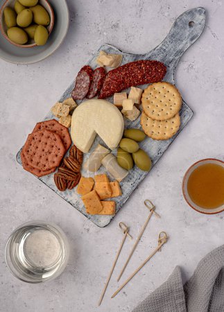Photo for Food photography of cheese; parmesan; cheddar; olive; cracker; crouton; nut; pecan; honey; white wine; salami; delicatessen - Royalty Free Image