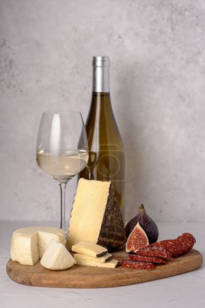 Foto de Fotografía de alimentos de queso; higo; vino blanco; salami seco con pimentón; lácteos; delicatessen - Imagen libre de derechos