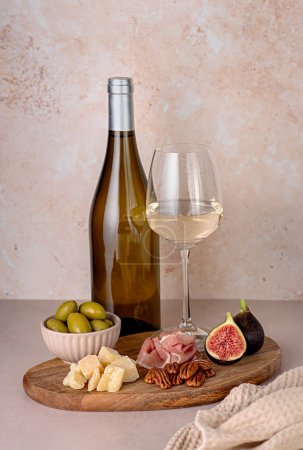 Photo for Food photography of white wine; cheese; parmesan; fig;  prosciutto, pecan, olive,  wineglass; bottle; chardonnay, sauvignon, winery - Royalty Free Image