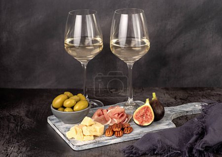 Foto de Fotografía de alimentos de vino blanco; queso; parmesano; higo; jamón; pacana; aceituna; rebanada; vino; chardonnay; sauvignon; bodega; fondo, celebración - Imagen libre de derechos