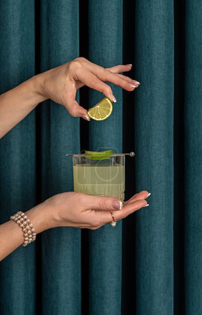 Photo for Photography of cocktail with lime, drink, mocktail, freshness, elegance, celebration, glamour, woman, jewellery, pearls, bracelet, beads, ring - Royalty Free Image