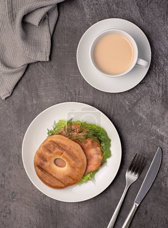 Foto de Fotografía de alimentos de bagel con salmón ahumado, crema, eneldo, lechuga romana, té con leche, sándwich, mañana, rebanada, desayuno, almuerzo - Imagen libre de derechos