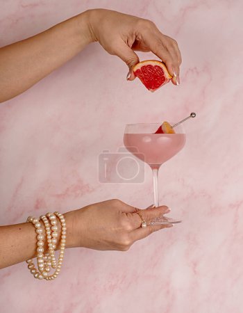 Photo for Photography of Cocktail with grapefruit, Drink, Mocktail, Freshness, Elegance, woman, jewellery, pearls, bracelet, beads, ring, pink, Celebration, - Royalty Free Image