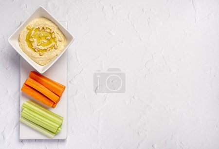 Téléchargez les photos : Photographie culinaire vierge de houmous, céleri, carotte, collation, trempette, vegan, végétarien, pois chiches, partager, pique-nique - en image libre de droit