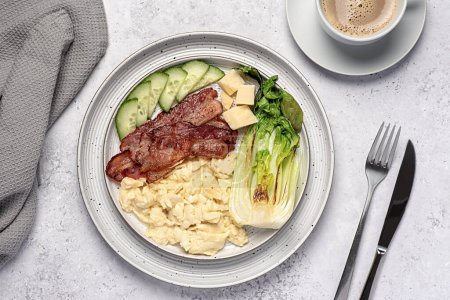 Photo for Food photography of breakfast; scrambled egg; fried bacon, cucumber, bok choi; cheese parmesan, keto diet; brunch;  background - Royalty Free Image