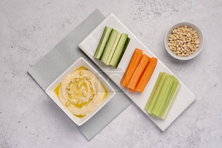 Photo for Food photography of hummus, celery, carrot, cucumber,  snack, dip, vegan, vegetarian, chickpea, share, picnic - Royalty Free Image