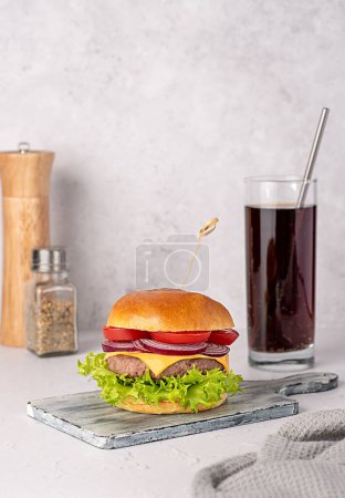 Photo for Food photography of hamburger, cheese, cheeseburger, sandwich, beef, bun, lettuce, tomato, onion, soda, drink, cola, background, hungry, american, restaurant, snack, meal - Royalty Free Image
