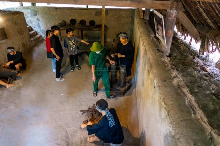 Photo for Cu Chi, Viet Nam - 20 May 2023: The Cu Chi tunnels.  The tour guide is showing the weapon making site. Famous tourist attraction in Vietnam - Royalty Free Image