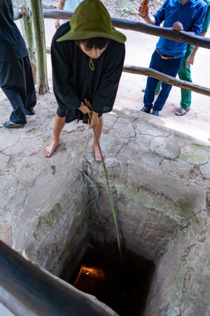 Photo for Cu Chi, Viet Nam - 20 May 2023: The Cu Chi tunnels. A guide demonstrating how a Vietcong hide into the Tunnel. It's used in Vietnam war. Famous tourist attraction in Vietnam - Royalty Free Image