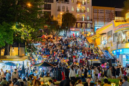 Téléchargez les photos : Da Lat, Viet Nam - 3 juin 2023 : Da Lat Market night skyline night view with lights attire des milliers de personnes marchant le long de la route commerçante animée du tourisme urbain à Da Lat. - en image libre de droit