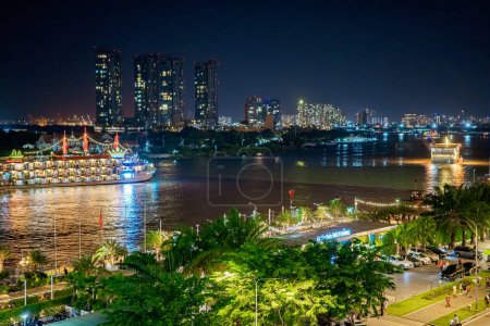 Téléchargez les photos : Ho Chi Minh, Viet Nam - 6 août 2023 : Riverboat sur la rivière Saigon la nuit, au loin se trouve le bâtiment Landmark 81, le plus haut bâtiment du Vietnam - en image libre de droit