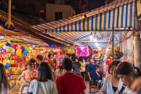 Téléchargez les photos : Ho Chi Minh Ville, Vietnam - 1 septembre 2023 : Les gens visitent et achètent des lanternes traditionnelles colorées suspendues sur la rue Luong Nhu Hoc, district 5 pendant la fête de la mi-automne. Amusant et heureux. Concentration sélective. - en image libre de droit