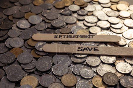 Photo for A close-up photo of Indian rupees coins spread on a table, with the word "Retirement" written in a stick - Royalty Free Image