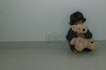 Foto de Una niña angustiada se reclina en el suelo, su mente corriendo con pensamientos de desesperación. - Imagen libre de derechos