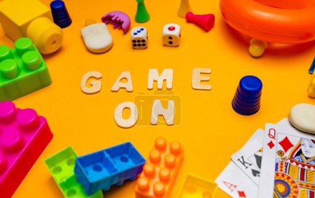 Photo for A close-up photo of Scrabble game letters spelling out the phrase "Game On." - Royalty Free Image