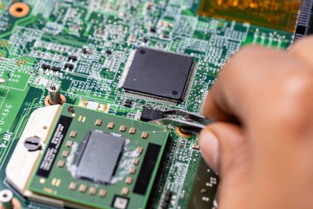 Photo for Technician meticulously repairs a laptop motherboard using specialized tools - Royalty Free Image