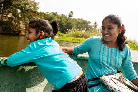 a mother and daughter weave their way through the green waters of Kerala
