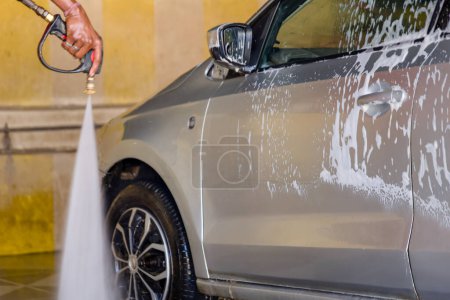 Foto de Ver un coche sucio transformado en una belleza impecable con el poder satisfactorio de un chorro de agua de alta presión y espuma de lavado de coches gruesa - Imagen libre de derechos