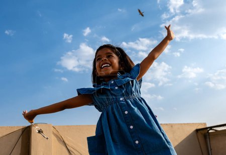 Niedliche indische kleines Mädchen springen in die Luft mit blauem Himmel backgro