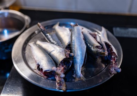 A Fresh sardines in a stainless steel tray in kitchen ready to cook
