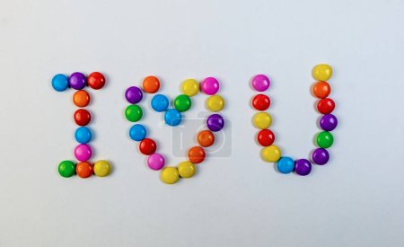Playful candy letters in a rainbow of colors spell out "I love you" on a white background