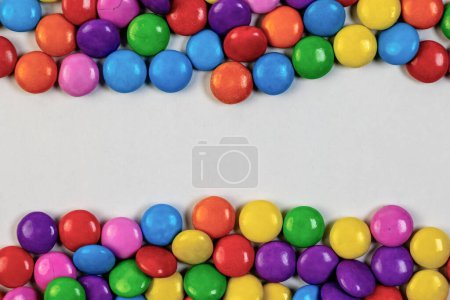 A delightful explosion of colorful candies spills across a crisp white background, leaving plenty of room for your personalized message