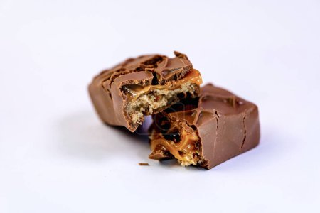A close-up photo of a mouthwatering chocolate bar packed with chunks of nuts
