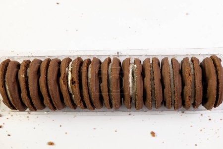 A close-up view of delicious chocolate cookies with a dollop of creamy filling on a clean white background