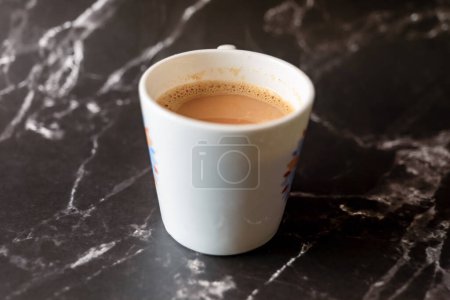 A photorealistic close-up of a steaming cup of coffee on a sleek black marble surface
