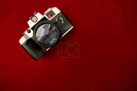 Ein hochauflösendes Bild mit einer Vintage-Kamera, die flach auf einer festen roten Oberfläche positioniert ist