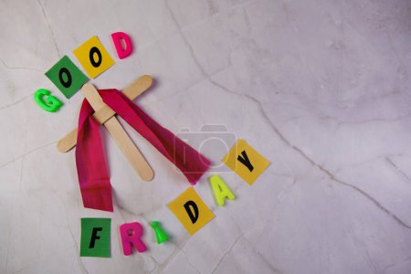 Photo for Simple wooden cross standing upright against a clean white background. The words "Good Friday" are spelled out - Royalty Free Image