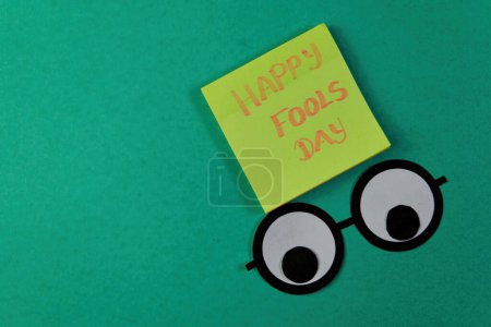 Foto de Prepárate para reírte Esta imagen juguetona presenta el mensaje "Feliz Día de los Tontos" que se muestra en una superficie de madera envejecida - Imagen libre de derechos