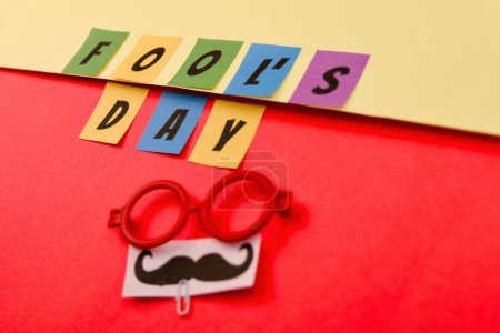 Get ready for some laughs with this vibrant image featuring a jumble of colorful letters and a pair of wacky eyeglasses on a bright red background