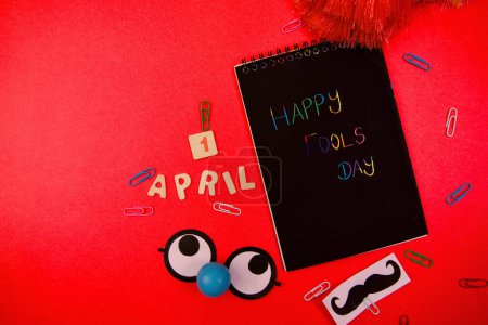 Spread laughter with this whimsical greeting card featuring a mustache and blackboard paper clips on a red background