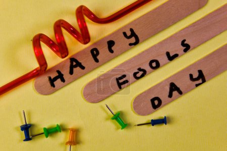 Foto de Prepárate para reírte Esta imagen juguetona presenta el mensaje "Feliz Día de los Tontos" que se muestra en una superficie de madera envejecida - Imagen libre de derechos
