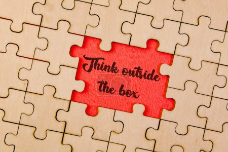 Interconnected jigsaw puzzle pieces coming together to create the phrase 'Think Outside the Box'
