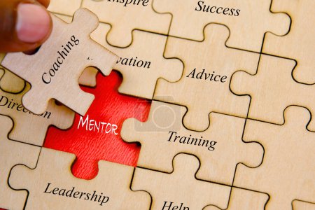 Konzeptbild, das die Idee der Mentorship durch ineinander greifende Puzzleteile veranschaulicht, die sich zu dem Wort "Mentoring" zusammenfügen"