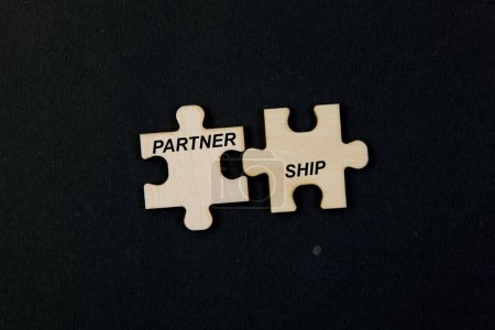 Schwarzer Hintergrund unterstreicht die ineinander greifenden Puzzleteile, die das Wort "PARTNER SHIP" bilden".