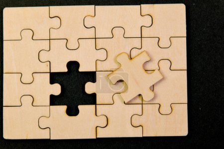 Scattered jigsaw puzzle pieces on a black background symbolize a business challenge that needs to be solved