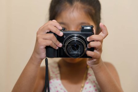 Una vista de cerca de una cámara clásica sostenida por un niño, destacando los detalles intrincados de la cámara y provocando una sensación de asombro.