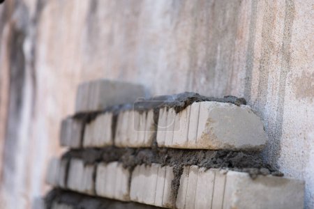 Photo for A neatly stacked pile of concrete blocks sits on a construction site, ready to be used for the foundation of a new house - Royalty Free Image