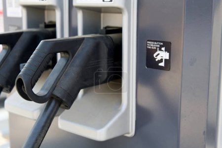 Close-up shot of a modern electric charging station at a gas station. This image represents the growing adoption of electric vehicles and the potential for traditional gas stations