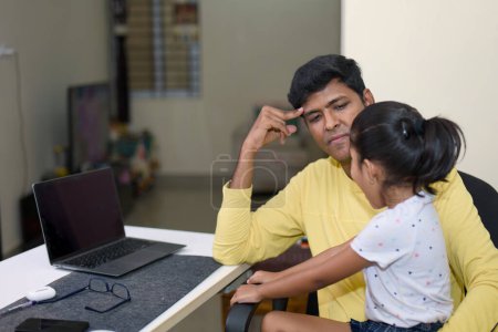 Esta imagen es sobre papá indio conecta con la hija mientras trabaja de forma remota