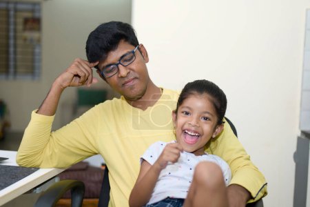Ein fröhlicher indischer Mann und seine kleine Tochter teilen sich einen verspielten Moment im Haus. Dieses Bild ist ideal für Konzepte des familiären Miteinanders