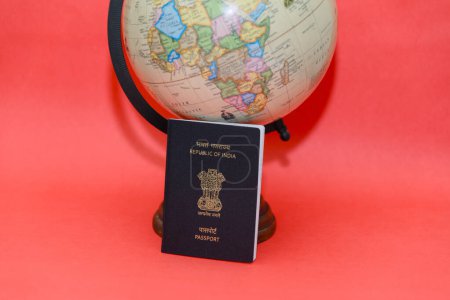 Lancez vos rêves de voyage avec un passeport classique et un globe terrestre reposant sur un fond rouge vif. Grand espace de copie