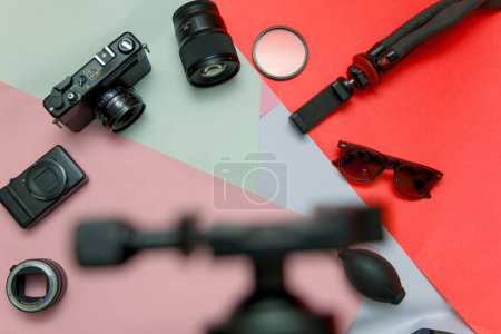 Una vibrante disposición plana que muestra el equipo esencial de un fotógrafo profesional, incluyendo una cámara, lentes, filtros, trípode y tarjetas de memoria.