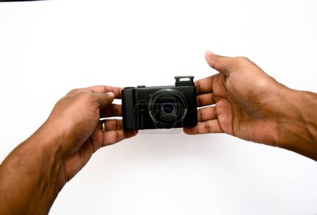 A close-up image of a photographer's hands securely holding a professional camera body against a clean, white background