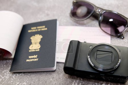 Cette image parle de passeport indien caméra et lunettes de soleil sur un fond gris concept de voyage