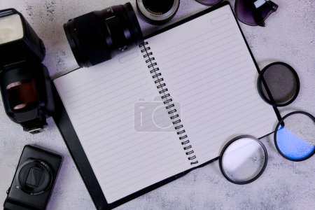 This image is about Blank notepad with camera and lenses on a white background.